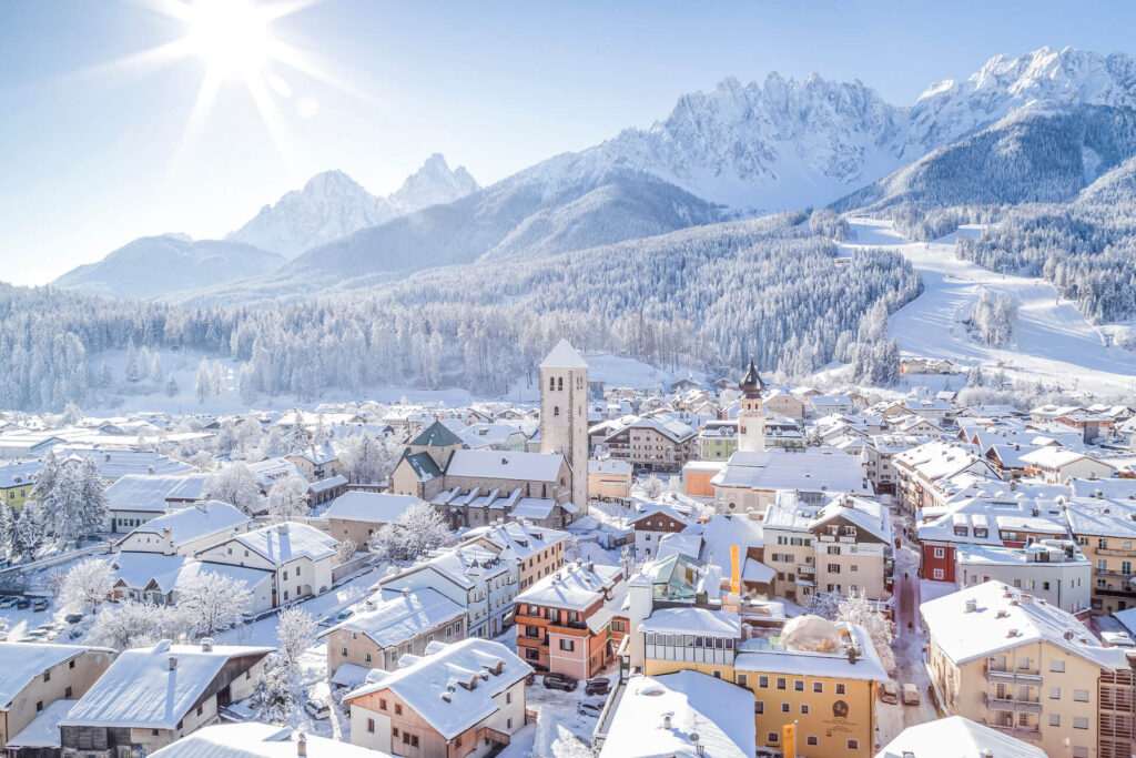 One of 3 Zinnen Dolomites' villages, covered in snow, on a sunny winter day