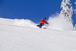 Skiing down a ski run on a bluebird day at 49 Degrees North