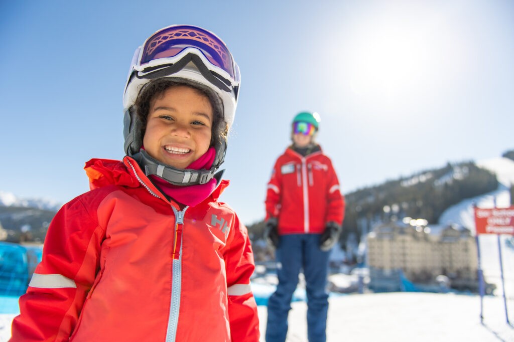 Picture of a child at ski and snowboard school with instructor in background