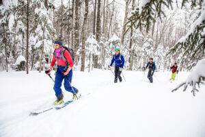 Skiers hiking up Black Mountain through the trees