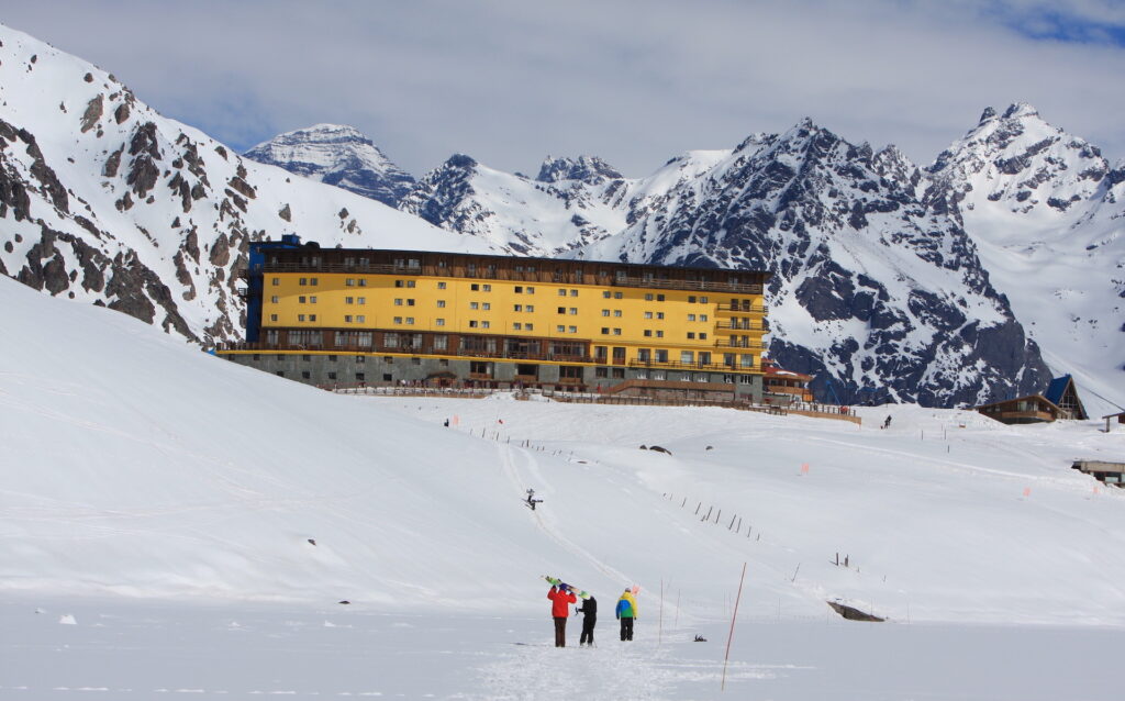 Skiers/snowboarders walking up to Hotel Portillo in the snow