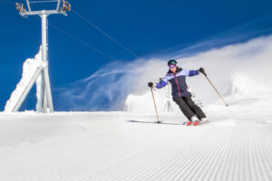 Best Spring skiing North America, female skiing bluebird day.