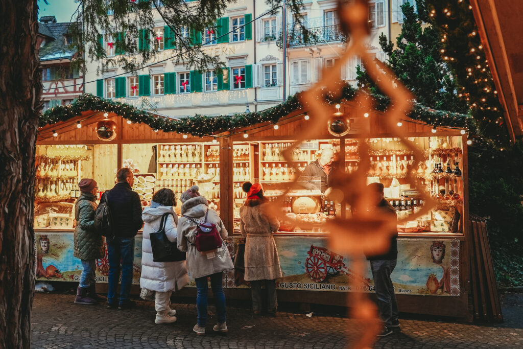 People shopping at Lucerne Christmas market at dusk