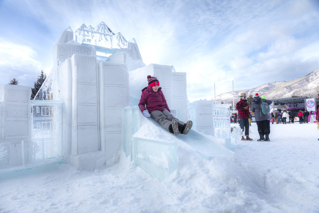 Kid sliding down ice slide at Wintersköl event in Aspen