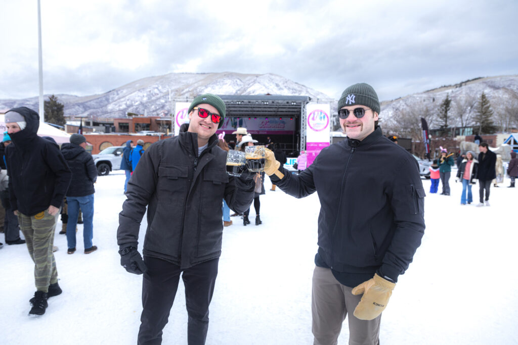 Two men toasting at Wintersköl Beer Festival in Aspen