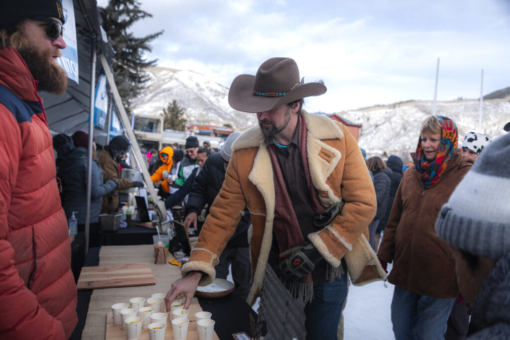 Person in a cowboy hat grabbing soup from Wintersköl Soupsköl event in Aspen