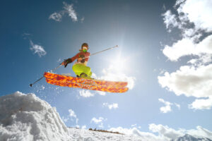 Woman catching air on a ski jump on a sunny day